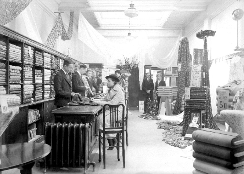 Black and white picture from 1938 showing customers and staff in the fabric department of Charles Babcock's and Co Ltd