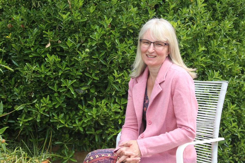 Professor Rhona Sharpe sat in a garden 