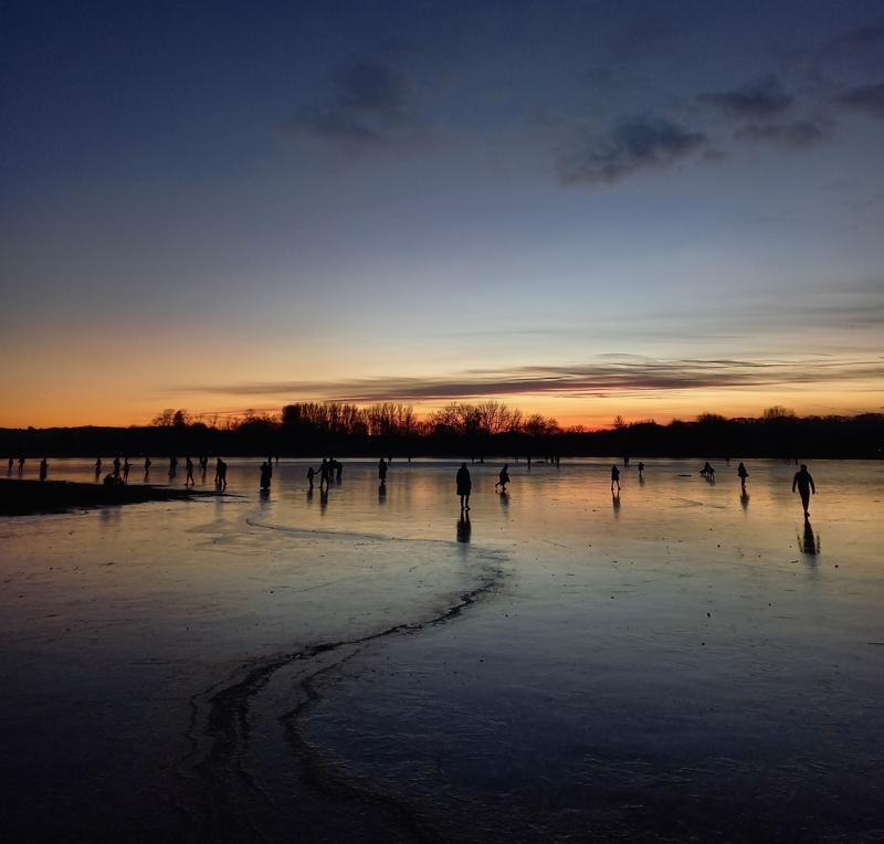 frozen-over Port Meadow in Oxford with people walking over the ice