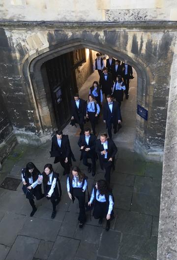 Arial view of students walking through an archway in their subfusc