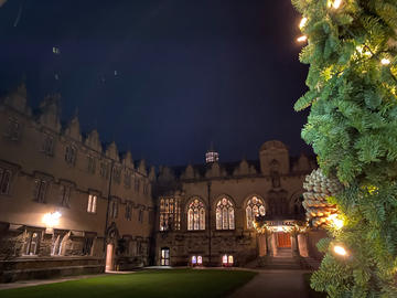Oriel College's quad at night with Christmas decorations on the building