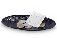 Plate with receipt and coins left as tip